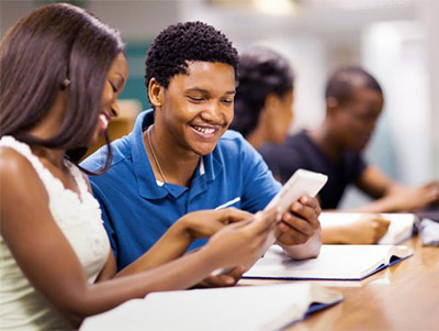 African-American college students studying textbooks in class