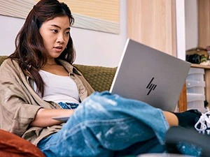 Asian student using HP Laptop in dorm