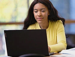 Young college female studying on Lenovo Laptop