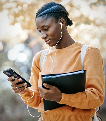 Black college student listening to music on phone on campus