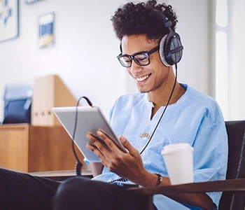 Black male student using iPad for online class