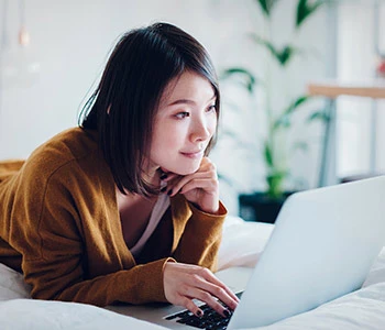 Asian female student using laptop for online college